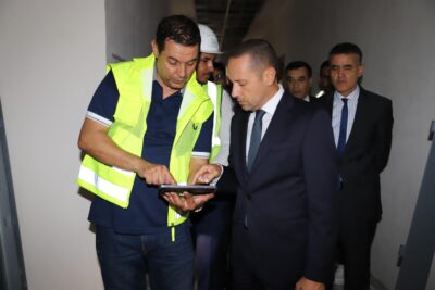 في إطار برنامج الزيارات الميدانية التي يباشرها وزير الصحة والحماية الاجتماعية، السيد أمين التهراوي، إلى مختلف جهات المملكة، تنفيذا للتوجيهات الملكية السامية الهادفة إلى تحسين وتجويد العرض الصحي الوطني، قام السيد الوزير، يومه الأربعاء 17 شتنبر 2025، بزيارة عمل إلى كل من إقليمي الناظور والدريوش، شملت عددا من المؤسسات الصحية والمشاريع الاستشفائية المهيكلة. واستهل السيد الوزير جولته بزيارة المستشفى الحسني بالناظور، حيث وقف على مستوى الخدمات الصحية المقدمة للمواطنات والمواطنين، واطلع على أداء مختلف الأقسام والمصالح الطبية والجراحية والتقنية، فضلا عن معاينة جاهزية الوحدات الاستشفائية والتجهيزات المتوفرة.  إثر ذلك، قام السيد الوزير رفقة عامل الناضور السيد جمال الشعراني، بزيارة ورش بناء المستشفى الإقليمي الجديد بسلوان، الذي ينجز على وعاء عقاري تبلغ مساحته 161.193 متر مربع، منها 26.562 متر مربع مغطاة، بطاقة استيعابية تصل إلى 250 سريرا، وبغلاف مالي إجمالي قدره 560 مليون درهم. ويضم هذا المشروع الاستشفائي المهيكل أقساماً متخصصة في الجراحة والطب العام وطب الأم والطفل، إضافة إلى المستعجلات، وحدة الإنعاش، المركب الجراحي، التصوير الطبي والمختبر، إلى جانب العيادات الخارجية ومستشفى النهار وقسم طب الأسنان، ومرافق أخرى صحية وإدارية، وقد بلغت نسبة تقدم الأشغال به حوالي 80%، ويرتقب أن يتم استكمال المشروع في أفق فبراير 2026.  من جهة أخرى، زار السيد الوزير بمعية عامل الدرويش السيد عبد السلام فريندو شملت الزيارة المستشفى الإقليمي بالدريوش، الذي تم افتتاحه في يناير 2022 بطاقة 150 سريرا، ويقدم خدمات متنوعة لفائدة ساكنة تقدر بنحو 190 ألف نسمة، حيث عاين السيد الوزير مستوى الخدمات الصحية المقدمة، والتقى بالأطر الطبية والتمريضية والإدارية، مؤكدا أهمية تحسين ظروف التكفل بالمرضى والارتقاء بجودة الخدمات داخل هذه المؤسسة.  واختتم السيد الوزير والوفد المرافق له زيارته بتفقد مستشفى القرب بميضار، الذي أنجز بطاقة استيعابية تصل إلى 45 سريرا، وعلى مساحة إجمالية تناهز 32.339 متر مربع (منها 5.754 متر مربع مغطاة)، وبكلفة إجمالية قدرها 99 مليون درهم. ويضم المستشفى أقساما متعددة تشمل الطب والجراحة وطب الأم والطفل، إضافة إلى المختبر، الاستشارات الخارجية، الصيدلية، المشرحة والمرافق الداعمة، فضلا عن برمجة إحداث وحدة للإنعاش.  وبذات المناسبة، التقى السيد الوزير بمهنيي الصحة العاملين بهذه المؤسسات، الذين قدموا تشخيصا للوضع بما في ذلك المشاكل والإكراهات التي تستوجب التدخل العاجل والفوري لضمان تجويد الخدمات الصحية، لاسيما توفير الأدوية والمستلزمات الطبية وصيانة التجهيزات والآليات، وتوفير الموارد البشرية.  وفي هذا الصدد، أكد السيد الوزير أن الوزارة ستعمل على حل جميع المشاكل والتحديات المطروحة في القريب العاجل لضمان تقديم خدمات صحية ذات جودة للساكنة المستهدفة في هذه الأقاليم.  وتندرج هذه الزيارة في إطار مواصلة سياسة القرب والإنصات المباشر لانتظارات المواطنات والمواطنين ومهنيي الصحة، وذلك من خلال برنامج متواصل من الجولات الميدانية التي يقودها السيد الوزير شخصيا إلى مختلف جهات وأقاليم المملكة.     ويهدف هذا التوجه إلى الوقوف بشكل ملموس على واقع المنظومة الصحية، من حيث البنيات التحتية والتجهيزات والموارد البشرية، وكذا الاطلاع على حاجيات الساكنة المحلية وتحدياتها، وذلك انسجاما مع التوجيهات الملكية السامية الداعية إلى إصلاح عميق وشامل للقطاع الصحي، بما يضمن تحسين ولوج المواطنات والمواطنين إلى خدمات صحية ذات جودة، والارتقاء بالمؤسسات الصحية لتستجيب للمعايير الوطنية والدولية.   وزير الصحة والحماية الاجتماعية، مؤسسات صحية، الناظور، الدريوش