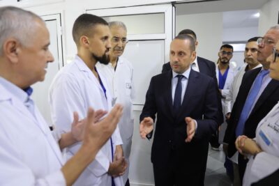 في إطار برنامج الزيارات الميدانية التي يباشرها وزير الصحة والحماية الاجتماعية، السيد أمين التهراوي، إلى مختلف جهات المملكة، تنفيذا للتوجيهات الملكية السامية الهادفة إلى تحسين وتجويد العرض الصحي الوطني، قام السيد الوزير، يومه الأربعاء 17 شتنبر 2025، بزيارة عمل إلى كل من إقليمي الناظور والدريوش، شملت عددا من المؤسسات الصحية والمشاريع الاستشفائية المهيكلة. واستهل السيد الوزير جولته بزيارة المستشفى الحسني بالناظور، حيث وقف على مستوى الخدمات الصحية المقدمة للمواطنات والمواطنين، واطلع على أداء مختلف الأقسام والمصالح الطبية والجراحية والتقنية، فضلا عن معاينة جاهزية الوحدات الاستشفائية والتجهيزات المتوفرة.  إثر ذلك، قام السيد الوزير رفقة عامل الناضور السيد جمال الشعراني، بزيارة ورش بناء المستشفى الإقليمي الجديد بسلوان، الذي ينجز على وعاء عقاري تبلغ مساحته 161.193 متر مربع، منها 26.562 متر مربع مغطاة، بطاقة استيعابية تصل إلى 250 سريرا، وبغلاف مالي إجمالي قدره 560 مليون درهم. ويضم هذا المشروع الاستشفائي المهيكل أقساماً متخصصة في الجراحة والطب العام وطب الأم والطفل، إضافة إلى المستعجلات، وحدة الإنعاش، المركب الجراحي، التصوير الطبي والمختبر، إلى جانب العيادات الخارجية ومستشفى النهار وقسم طب الأسنان، ومرافق أخرى صحية وإدارية، وقد بلغت نسبة تقدم الأشغال به حوالي 80%، ويرتقب أن يتم استكمال المشروع في أفق فبراير 2026.  من جهة أخرى، زار السيد الوزير بمعية عامل الدرويش السيد عبد السلام فريندو شملت الزيارة المستشفى الإقليمي بالدريوش، الذي تم افتتاحه في يناير 2022 بطاقة 150 سريرا، ويقدم خدمات متنوعة لفائدة ساكنة تقدر بنحو 190 ألف نسمة، حيث عاين السيد الوزير مستوى الخدمات الصحية المقدمة، والتقى بالأطر الطبية والتمريضية والإدارية، مؤكدا أهمية تحسين ظروف التكفل بالمرضى والارتقاء بجودة الخدمات داخل هذه المؤسسة.  واختتم السيد الوزير والوفد المرافق له زيارته بتفقد مستشفى القرب بميضار، الذي أنجز بطاقة استيعابية تصل إلى 45 سريرا، وعلى مساحة إجمالية تناهز 32.339 متر مربع (منها 5.754 متر مربع مغطاة)، وبكلفة إجمالية قدرها 99 مليون درهم. ويضم المستشفى أقساما متعددة تشمل الطب والجراحة وطب الأم والطفل، إضافة إلى المختبر، الاستشارات الخارجية، الصيدلية، المشرحة والمرافق الداعمة، فضلا عن برمجة إحداث وحدة للإنعاش.  وبذات المناسبة، التقى السيد الوزير بمهنيي الصحة العاملين بهذه المؤسسات، الذين قدموا تشخيصا للوضع بما في ذلك المشاكل والإكراهات التي تستوجب التدخل العاجل والفوري لضمان تجويد الخدمات الصحية، لاسيما توفير الأدوية والمستلزمات الطبية وصيانة التجهيزات والآليات، وتوفير الموارد البشرية.  وفي هذا الصدد، أكد السيد الوزير أن الوزارة ستعمل على حل جميع المشاكل والتحديات المطروحة في القريب العاجل لضمان تقديم خدمات صحية ذات جودة للساكنة المستهدفة في هذه الأقاليم.  وتندرج هذه الزيارة في إطار مواصلة سياسة القرب والإنصات المباشر لانتظارات المواطنات والمواطنين ومهنيي الصحة، وذلك من خلال برنامج متواصل من الجولات الميدانية التي يقودها السيد الوزير شخصيا إلى مختلف جهات وأقاليم المملكة.     ويهدف هذا التوجه إلى الوقوف بشكل ملموس على واقع المنظومة الصحية، من حيث البنيات التحتية والتجهيزات والموارد البشرية، وكذا الاطلاع على حاجيات الساكنة المحلية وتحدياتها، وذلك انسجاما مع التوجيهات الملكية السامية الداعية إلى إصلاح عميق وشامل للقطاع الصحي، بما يضمن تحسين ولوج المواطنات والمواطنين إلى خدمات صحية ذات جودة، والارتقاء بالمؤسسات الصحية لتستجيب للمعايير الوطنية والدولية.   وزير الصحة والحماية الاجتماعية، مؤسسات صحية، الناظور، الدريوش